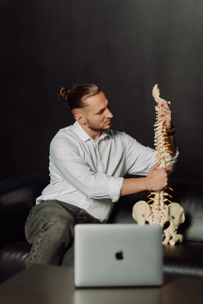 Diagnostyka bólu pleców w Uzdrovisko – specjalista wyjaśnia problem na modelu kręgosłupa.