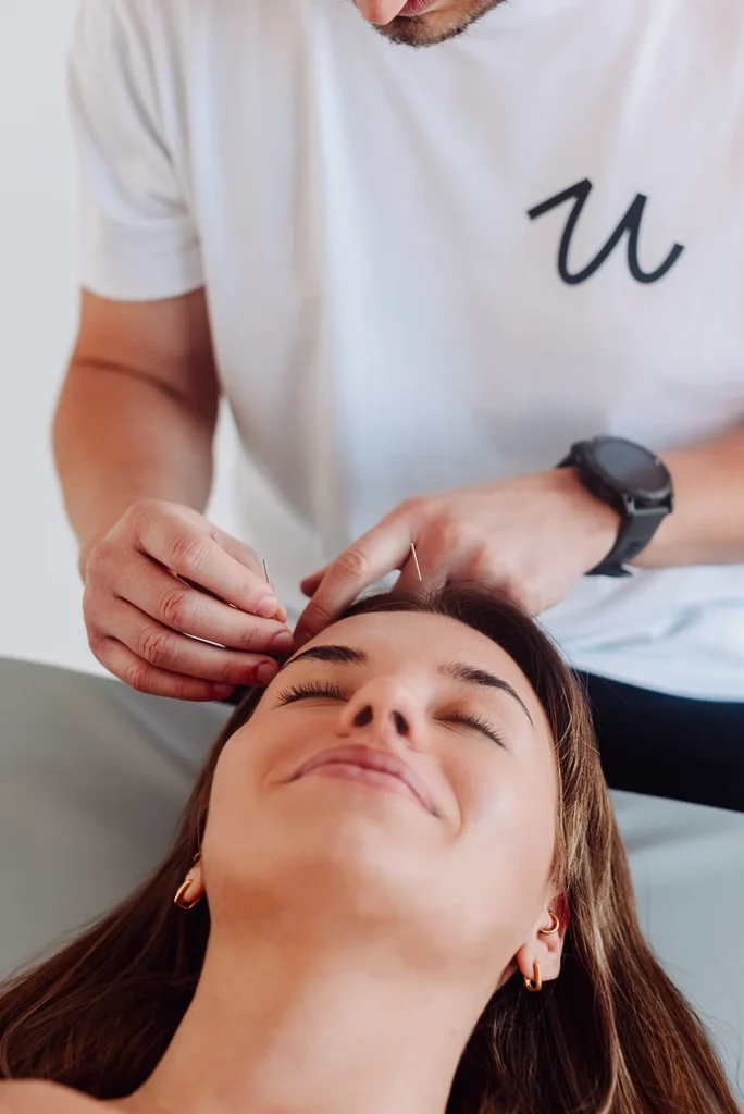 Zabieg akupunktury czaszki w gabinecie fizjoterapii Uzdrovisko Poznań – terapeuta aplikuje igły.